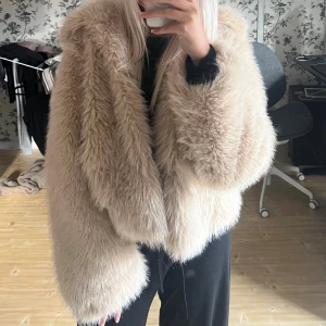 Beige pälsjacka från Noisy May - Säljer en fluffig och oversized beige pälsjacka från Noisy May. Jackan har bred krage, långa ärmar och är tillverkad i syntetiskt pälsmaterial. Perfekt för dig som vill ha en statement piece med lyxig vibe och skön komfort. Från storlek S.