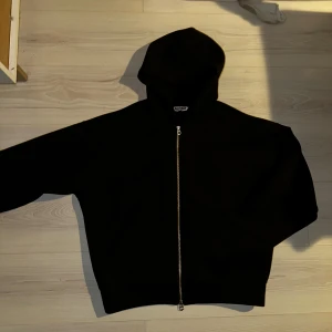 Scuba zip hoodie från weekday - Svart hoodie från Weekday med hel dragkedja framtill och huva. Tröjan har en klassisk, enkel design och är tillverkad i mjukt material som känns skönt mot huden. Perfekt för lager-på-lager och chill dagar.