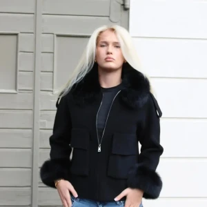 Fur Stockholm Stephanie päls kappa - Jackan är av ull och Kashmir alltså riktigt bra kvalite. Snygg svart kappa med fluffig päls runt krage och ärmslut. Jackan har två stora fickor framtill, dragkedja och en rak  passform. Perfekt för dig som vill sticka ut med en lyxig vibe i vinter.