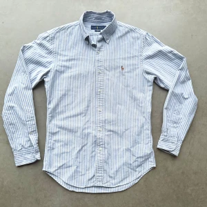 Ralph Lauren oxfordskjorta - Ljusblå/vitrandig skjorta i bomull från Ralph Lauren. Storlek herr Small slim fit