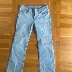 Levi's Superlow Boot ljusblå jeans - Ljusblå Levi's Superlow Boot jeans med klassisk femficksdesign och bootcut-ben. Jeansen har låg midja och är tillverkade i mjukt denim. Perfekta för dig som gillar retrovibbar och avslappnad stil.