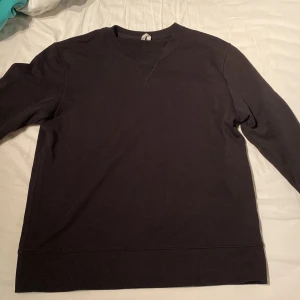 Svart sweatshirt från ARKET i bomull - En stilren svart sweatshirt från ARKET i storlek M. Tröjan har rund halsringning, långa ärmar och är tillverkad i mjuk bomull. Perfekt basic-plagg med relaxed fit och ribbade muddar vid ärmslut och nederkant.