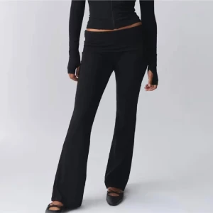 Svarta yogapants - Svarta bootcut yogabyxor med låg midja och stretchigt material. Byxorna har en bred linning och sitter tight upptill men släpper ut vid benen för en snygg siluett. Perfekta för en chill och trendig look.