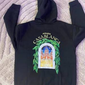 Svart hoodie från Casablanca - Svart hoodie från Casablanca med färgglatt tryck på bröstet och stor grafisk print på ryggen. Klassisk huva och känguruficka framtill. SAMMA DAG DU KÖPER SAMMA DAG JAG FRAKTAR 