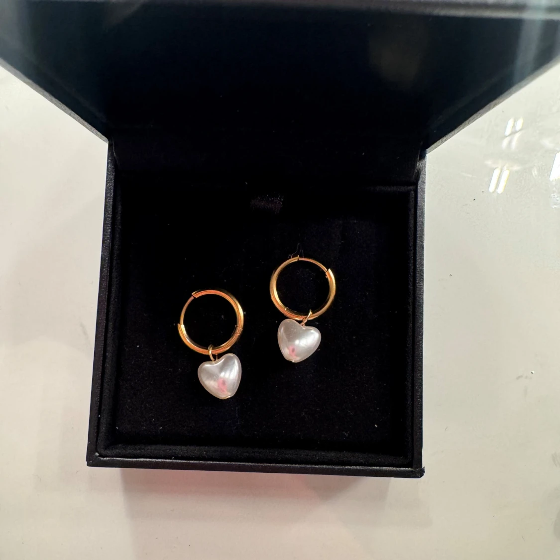 Guldiga örhängen med pärlhjärtan