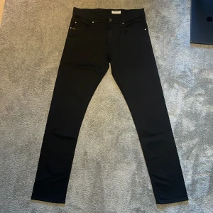 Svarta skinny jeans Tiger of Sweden - Helt nya svarta skinny jeans från Tiger of Sweden med klassisk femficksdesign och diskret logga på knappen. Perfekta för en clean och stilren look. Längd 107cm, midja 41.5cm