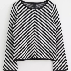 Randig svartvit tröja från Lindex - Snygg långärmad tröja från Lindex med svartvita diagonala ränder som möts i ett V-mönster framtill. Tröjan har rund halsringning och är tillverkad i mjukt stickat material. Perfekt för dig som gillar grafiska mönster och vill sticka ut lite extra.