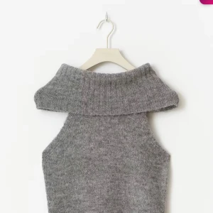 Grå stickad topp med polokrage - Säljer en grå stickad topp med bred, ribbad polokrage och ärmlös design. Helt ny med prislapp kvar. Vid intresse kan fler bilder skickas!