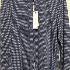 Blå slim fit skjorta Calvin Klein - Snygg blå skjorta från Calvin Klein med vit prickigt mönster och slim fit-passform. Skjortan har klassisk krage, knappar framtill och lång ärm. Perfekt för dig som gillar stilrena detaljer och modern look.