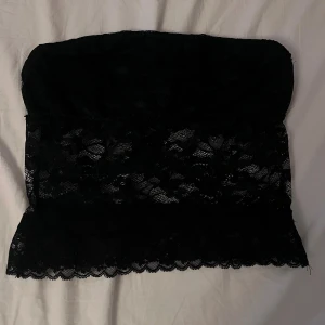 Svart fest topp  - Säljer en svart tubtopp i spets med blommigt mönster. Den är i storlek S och kommer inte till användning, har inte heller använt den innan💕