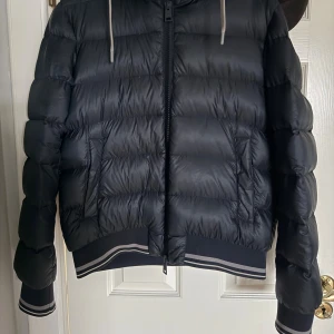 Marinblå herno jacka - Marinblå jacka från Herno perfekt nu inför kallare väder! Storlek S inga märkvärdiga defekter eller liknande. Lappar osv finns kvar i innerfickorna! En stor förpackning till jackan tillkommer med köpet! Storlek 54!