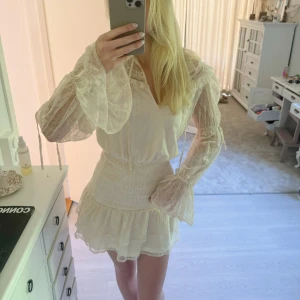 Vit volangklänning med spetsdetaljer/ studentklänning  - (  Säljer denna väldigt fina och mycket populära mini/korta klänningen i storlek S. Går inte längre att köpa! Super fint alternativ till studenten❤️(första bilden är egen bild! Klänning är kräm vit/vit, andra bilderna är samma fast i kritvit färg)