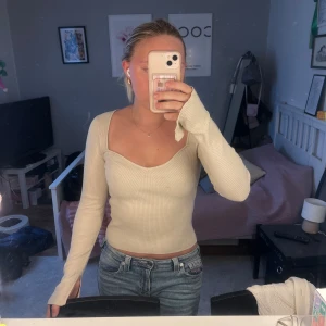 Långärmad topp - ångärmad topp från ginatricot. I cremevit, supersnygg urringning. Har slits på ärmarna.