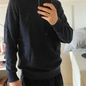 Mörkblå ulltröja från Selected Homme - Säljer en stilren mörkblå stickad tröja från Selected Homme. Tröjan har rund halsringning, ribbade muddar och är tillverkad i mjuk ullblandning. Perfekt för lager-på-lager och passar till både jeans och chinos.