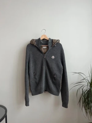 Moncler Maglione Tricot Cardigan Backpadded Grey M - Mycket bra skick, lite noppring och finns lite tecken på användning                                                                Storlek - M   Färg - Mörkgrön och en ton på grågrön  Mått - Axlar: 44cm   Längd: 65cm  Skriv om du har någon fråga :) 