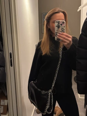 Svart tiamo kedjeväska - Säljer denna snygga kedjeväskan i svart skinn! Älskar denna men hittar tyvärr ej användning för den längre 🥹🪩        Märke: tiamo, Köpt för 599kr, jättebra skick! 