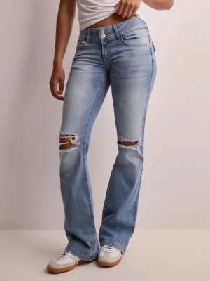 Ljusblå bootcut jeans med slitningar - Säljer ett par ljusblå jeans med bootcut passform och slitna hål över knäna. Jeansen har klassisk femficksdesign, dubbla knappar i midjan och är tillverkade i mjukt denimtyg. Perfekta för en avslappnad och trendig look.