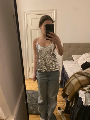 Glittrig silver linnetopp med paljetter - Fint glittrigt silverfärgat linne med tunna axelband och paljetter över hela toppen. Perfekt för dig som vill sticka ut och glänsa eller tex till nyår💗