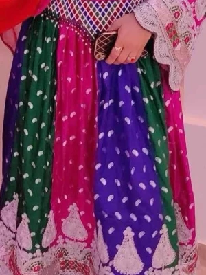 Färgstark långklänning med brodyr - Säljer en afghansk dräkt, långklänning i starka färger med gröna, blå och rosa paneler. Klänningen har vita prickar, detaljerad brodyr nertill och ett mönstrat liv med speglar och broderier. Ärmarna har spets och klänningen är i ett lätt, glansigt material. Standard stl. Använd 1 gång. Egendesignad och syd i Kabul. Har sjal och byxor till. 