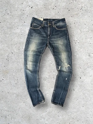 Blå slim fit jeans från Dondup - Kom med prisförslag!                                         Säljer ett par schyssta blå slim fit jeans från Dondup med slitna detaljer och snygga ljusa tvättar. Storlek W27-30L30 så de är 27 men passar till ungefär 28-30 i midjan också. 40cm breda i midjan. Han på bilden är 173cm. Passformen är tight och passar perfekt till alla dina outfits!👊 