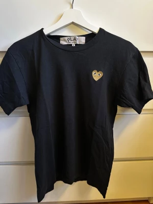 Svart Comme des Garçons PLAY t-shirt - Svart t-shirt från Comme des Garçons PLAY i storlek S. Köpt på NK i Stockholm 