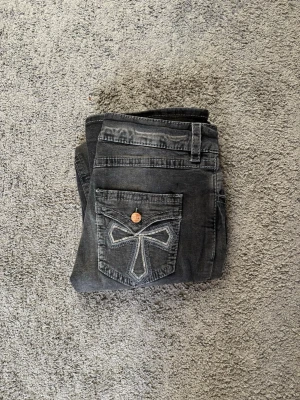 Svarta bootcut jeans från Gina Tricot - Snygga svarta jeans från Gina Tricot i storlek 164. Bootcut-modell med coola detaljer på bakfickan och kontrastsömmar. Jeansen har klassisk femficksdesign, knapp och dragkedja framtill. Perfekt för dig som gillar en lite bredare benslut.
