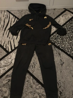 UFC tracksuit, Hoodie & Mjukisen - Mjukisen är mer använda än hoodien, ett hål finns i högra fickan med