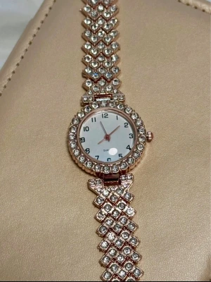 Klocka i Roséguld  - Roséguld färgad glittrig armbandsklocka med stenar. Ny! 