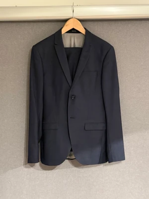 Tiger of Sweden Kostym - Mörkblå kostym med ljusblå accent från Tiger of Sweden. Blazern har storlek 46 och byxorna storlek 46. (I köpet tillkommer både byxor och blazer*)