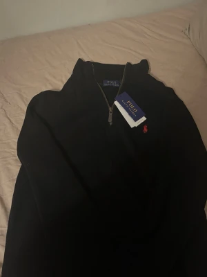 Svart half zip tröja från Polo Ralph Lauren -  Ny skick fet raffe zip, med tagg kvar (säljer för att de var för små) Storlek M, passar snarare S, köp och får en svart moncler pike på köpet!