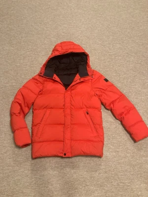 J.Lindeberg vinterjacka - J. Lindeberg puffer jacka i bra skick, den har en defekt se bild 6, den kan vara lite smutsig på vissa ställen men bara för att den varit i en garderob i sådana fall det finns inga fläckar eller hål. Storlek M passar sin storlek, passar mellan 180-185 cm. Hör av er om frågor!