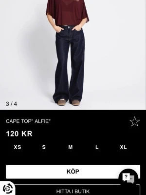 Vinröd blus  - Säljer en vinröd blus från Alfie med lös passform och korta, vida ärmar. Toppen har en enkel, rund halsringning och är tillverkad i ett lätt, transparent material som ger en luftig känsla. Perfekt att styla med jeans eller kjol.