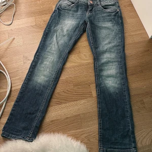 Blå jeans från C&A Here+There - Snygga blå jeans från C&A Here+There med klassisk femficksdesign och raka ben. Jeansen har en cool tvätt med ljusare partier framtill och bak, samt knapp och dragkedja i midjan. Perfekta för dig som gillar en enkel och stilren look. storlek 152