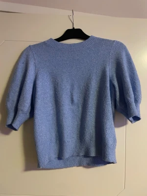 Ljusblå stickad tröja Vero Moda - Supersöt ljusblå stickad tröja från Vero Moda i storlek XS. Tröjan har puffiga trekvartsärmar och ribbade muddar vid hals, ärmslut och nederkant. Perfekt för dig som vill ha en chill men ändå stylish look till vardags.