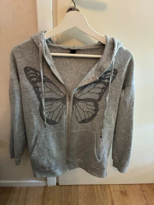Zip hoodie  - Säljer grå kofta med glitter fjäril på!
