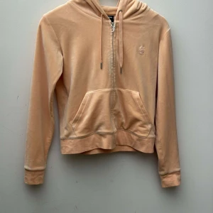 Aprikos velour hoodie från Juicy Couture - Supermjuk aprikos färgad hoodie från Juicy Couture i klassisk velour med dragkedja, huva och. Långärmad modell användt 3 gånger skriv ifall ni vill ha någon mer bild eller har några frågor 