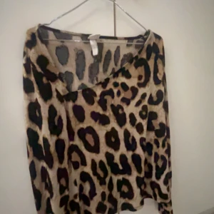 Leopardmönstrad långärmad tröja - Säljer en snygg långärmad tröja med leopardmönster i beige, brunt och svart. Tröjan har en avslappnad passform och är perfekt för dig som vill sticka ut lite extra. Mjuk och skön, passar till både jeans och kjol. Den är i storlek M men passar L. Priset går och diskuteras.