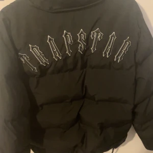 Trapstar svart pufferjacka - Svart pufferjacka från Trapstar. Knappt använd luva medföljer! Kan bytas mot moncler cardigan eller någon annan moncler så tveka inte på att skriva! Är priset fel kom med förslag 