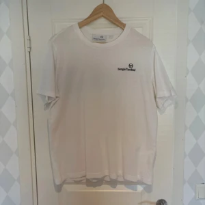 Sergio Tacchini T-shirt  - Säljer denna då den aldrig används.  Den sitter ej som L, kolla sista bilden för mått.  Finns lite missfärgningar.  Pris går att diskuteras.