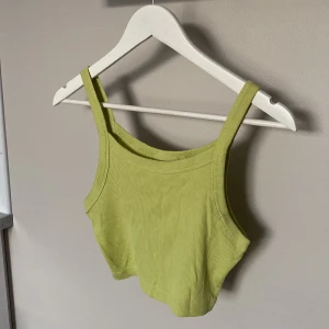 Ljusgrön ribbad crop top från Weekday  - Superfräsch ljusgrön ribbad crop top från Weekday, modell Kristy Crop Singlet i storlek S. Linnet har smala axelband och är croppad i modellen, perfekt till höga jeans eller shorts.
