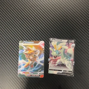 Lycanroc & Drampa V Pokémonkort - Två coola Pokémonkort: Lycanroc och Drampa V! Perfekt för dig som samlar, spelar eller bara älskar Pokémon. Färgstarka motiv och kraftfulla stats gör dessa kort till ett måste för unga fans och samlare. JAG VET INTE OM DE ÄR ÄKTA!!!!!