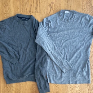 Grå tröjor Selected Homme & Filippa K - Två stilrena grå långärmade tröjor, en från Selected Homme i mörkare grått med rund hals och en från Filippa K i ljusare grått. Selected Homme-tröjan är i ekologisk bomull och kashmir, båda har klassisk passform och passar perfekt till jeans eller chinos.