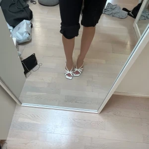 sandaler  - Snygga vita sandaler med kilklack och öppna tår. Skorna har flera tunna remmar som korsar över foten och ger en fräsch och somrig look. Perfekta för dig som vill ha både stil och komfort. Fyrkantig tå och justerbar rem runt hälen.