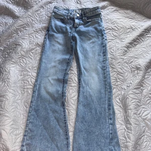 Ljusblå bootcut jeans från Lindex - Snygga ljusblå jeans från Lindex i modellen Freja. Jeansen har klassisk femficksdesign, normalhög midja och bootcut-ben som ger en retrovibe. Perfekta till sneakers eller boots. Tillverkade i mjukt bomullstyg för skön känsla hela dagen. Nypris 450