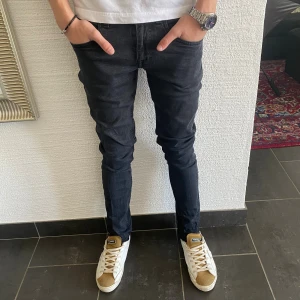 Tiger of Sweden Jeans - Säljer ett par svarta slim fit jeans i modellen Blackend. Jeansen har klassisk femficksdesign, smal passform och normal midja. Materialet är mjukt och stretchigt för en bekväm känsla. Perfekta för dig som gillar en stilren och modern look.
