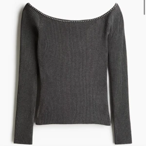 Mörkgrå offshoulder topp hm - Säljer en mörkgrå ribbad offshoulder topp med långa ärmar. Toppen har en snygg detalj med små silverfärgade nitar längs den vida halsringningen. Perfekt för dig som gillar stilrena plagg med en twist.