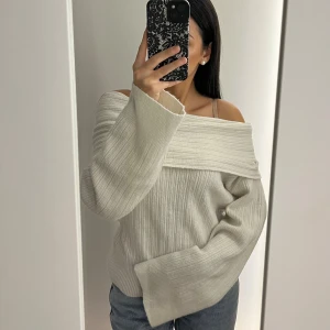 Offshoulder ribbad tröja - Superfin offshoulder stickad tröja i vit med bred ribbad kant upptill. Tröjan har lång ärm och är ribbstickad över hela, vilket ger en snygg och trendig look. Perfekt inför hösten!
