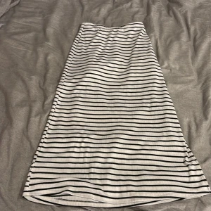 Randig långkjol från SHEIN, S - Vit och svart ribbad långkjol från SHEIN i storlek S. Kjolen har raka svarta ränder och är tillverkad i ett stretchigt, mjukt material. Perfekt för dig som gillar en clean och enkel stil med lite edge.