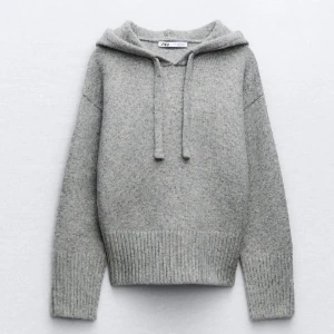 Grå stickad hoodie från Zara - Jättefin grå hoodie från Zara!! Supermjuk grå stickad hoodie från Zara med ribbade muddar och nederkant. Tröjan har huva med snörning och lång ärm, perfekt för en chill och snygg look. Passformen är normal och materialet känns riktigt cozy.