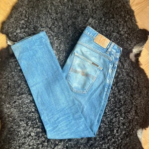 Nudie Jeans Grim Tim jeans W31 L32 - Ett par ljusblå slim fit jeans från Nudie. Storlek W31 L32 men passar lite mer W31 L31. Välanvända men har fortfarande mycket liv kvar✨. Bra denim och ekologisk bomull🤩 skriv gärna om fråga och lägg gärna prisförslag🤗